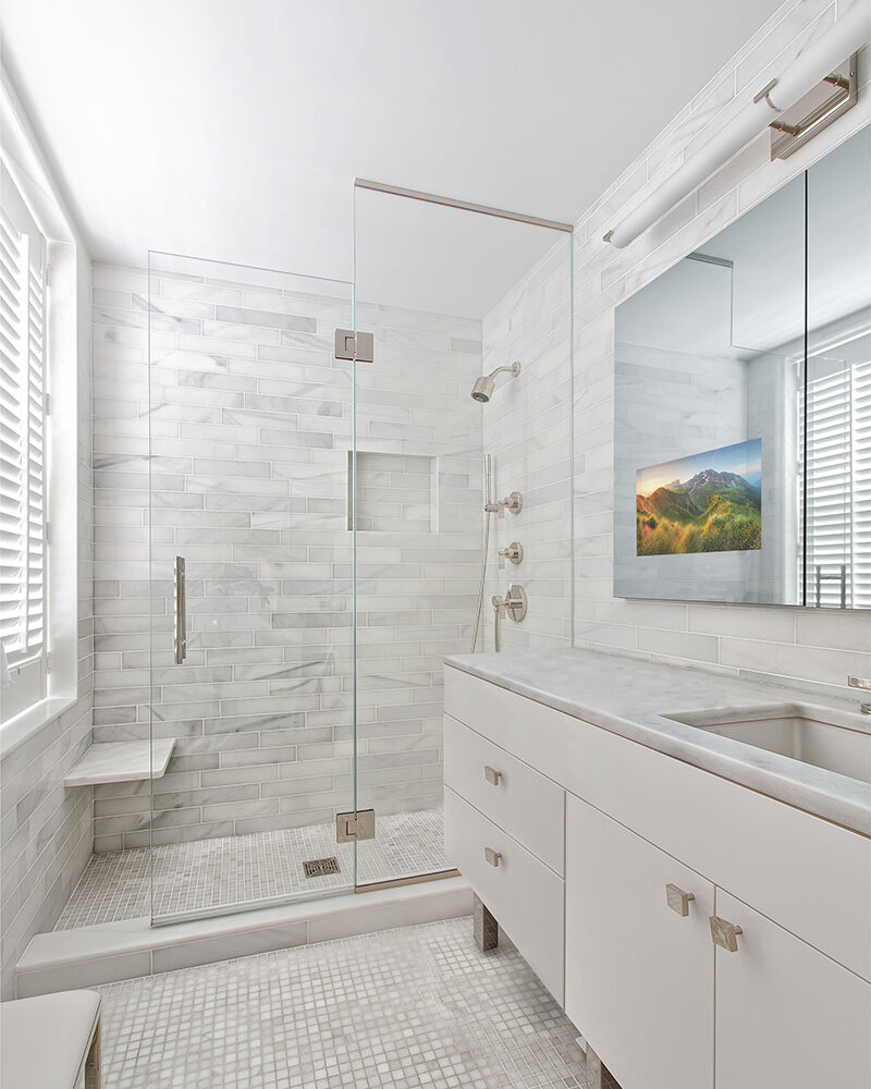 Modern bathroom vanity with a Seura Vanishing Vanity TV Mirror.